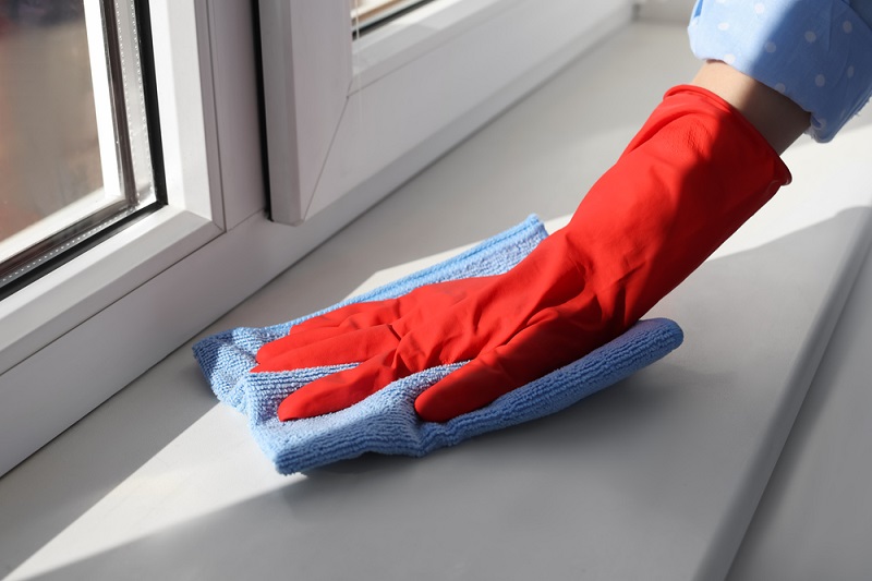 Wiping window sill with microfibre cloth