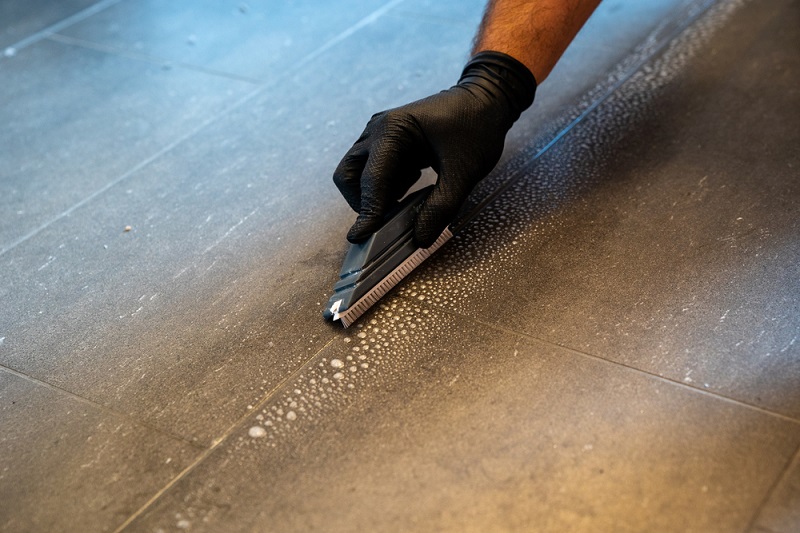 Cleaning tile grout with a brush