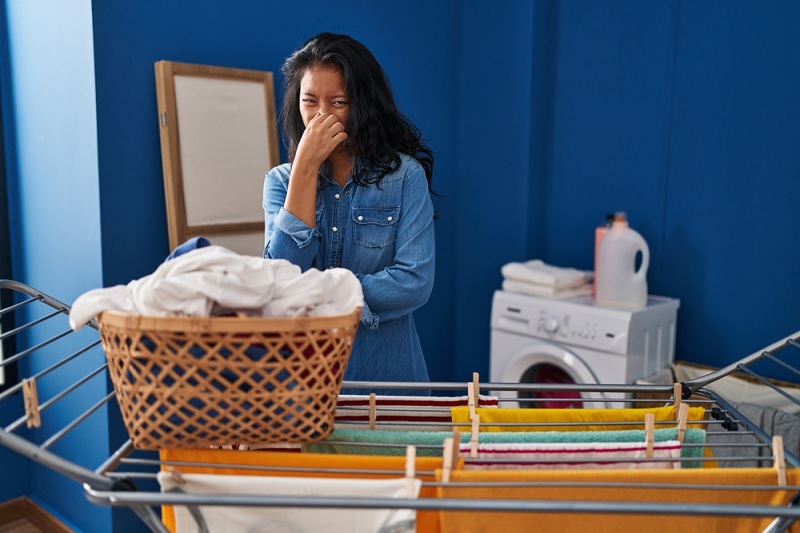 Woman doing laundry smelling clothes