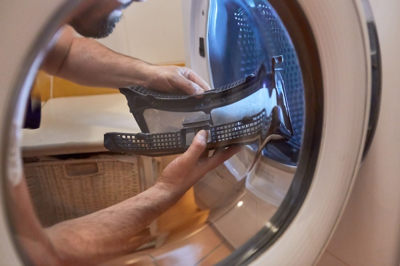 Man cleaning tumble dryer
