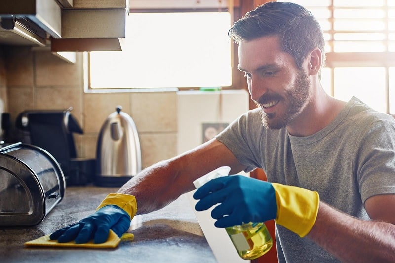 Man cleaning kitchen countertop