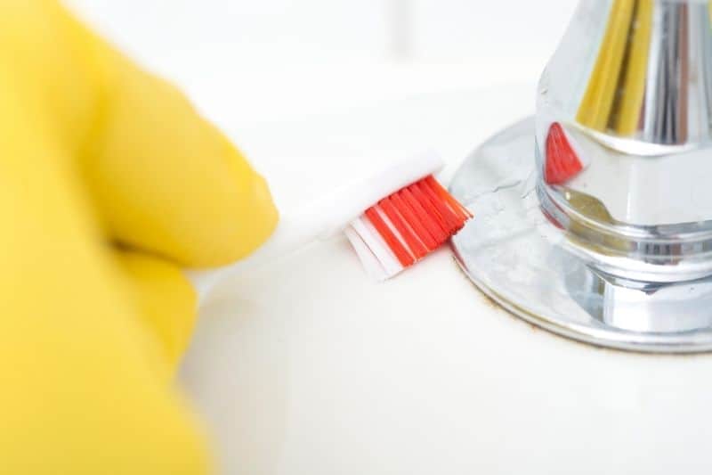 Cleaning Chrome Tap with Toothbrush