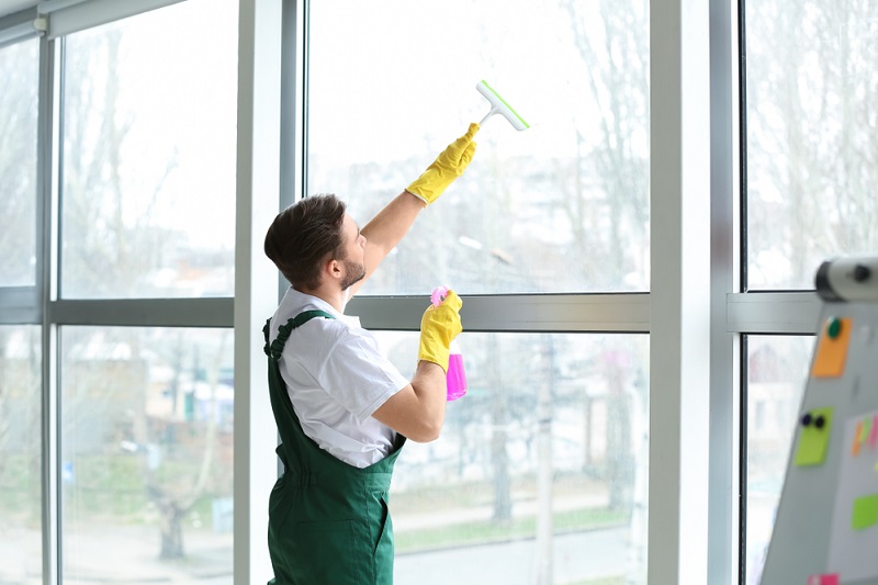 man cleaning big windows