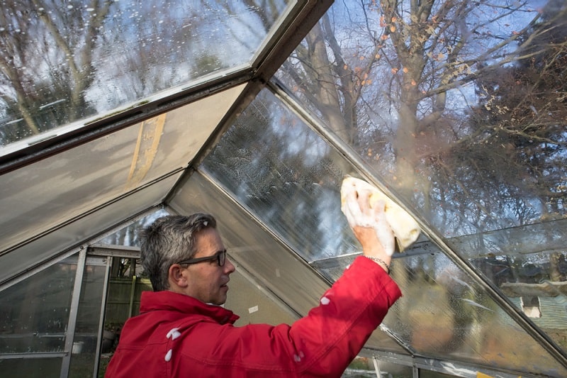 man cleaning conservatory windows