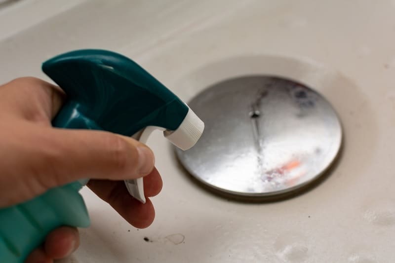 Cleaning shower plughole with spray