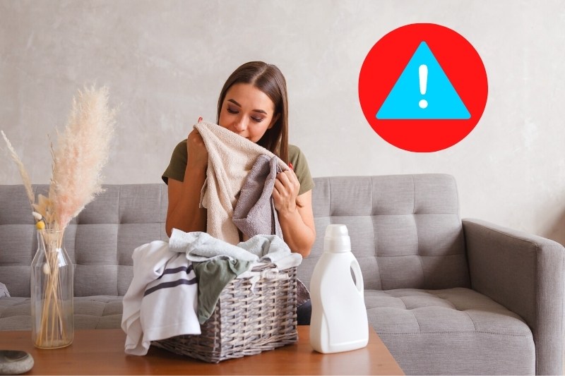 woman smelling washed clothes with fabric softener