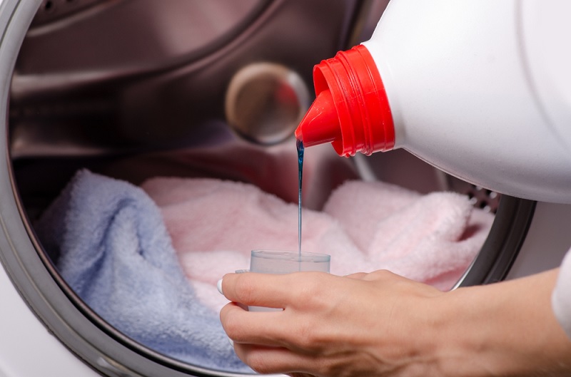 Pouring laundry liquid into cap