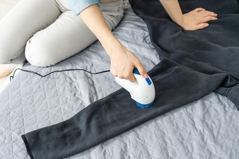 Woman using fabric shaver