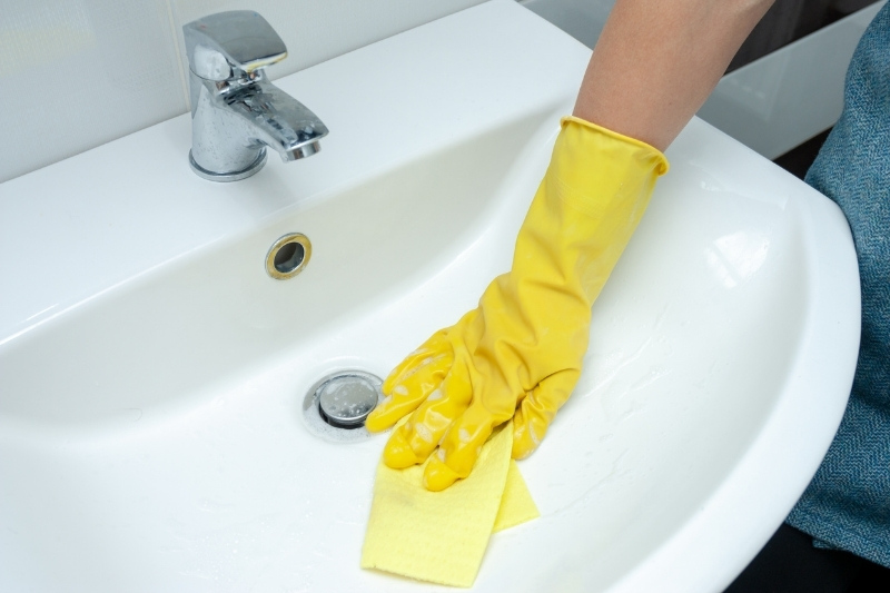 cleaning bathroom sink and taps