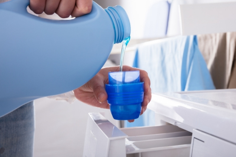 pouring fabric conditioner in bottle cap