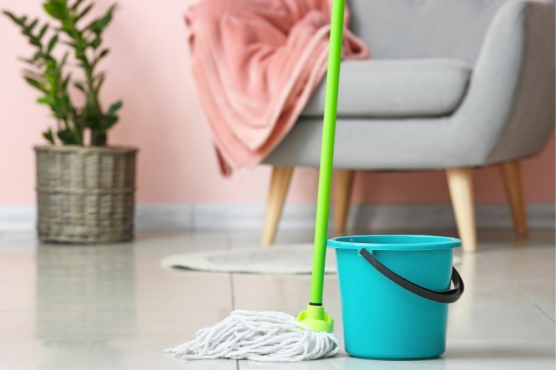 cleaning floor using mop and bucket