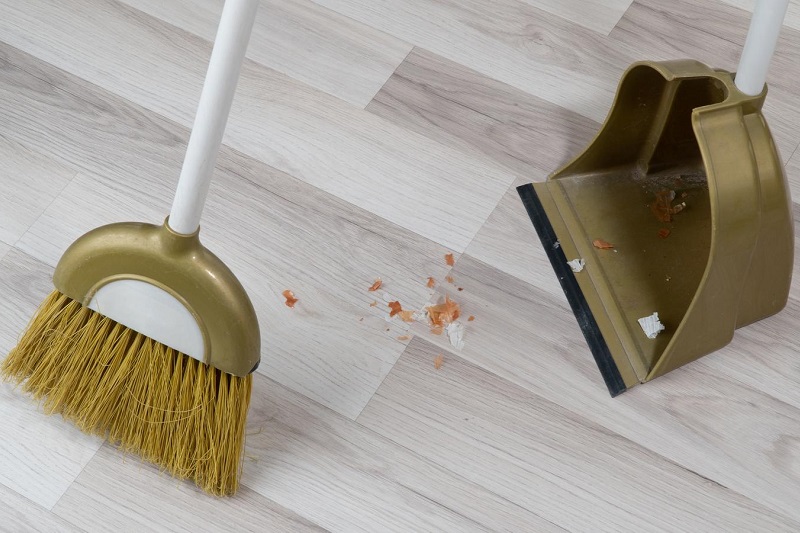 Dustpan and brush on laminate floor