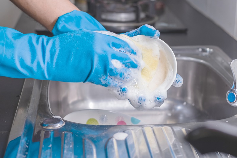 Washing dishes wearing gloves