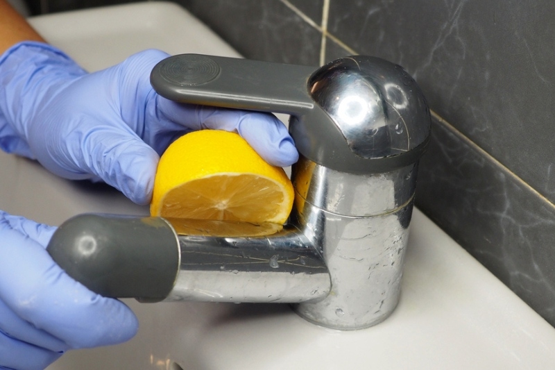 clean chrome faucet with lemon juice