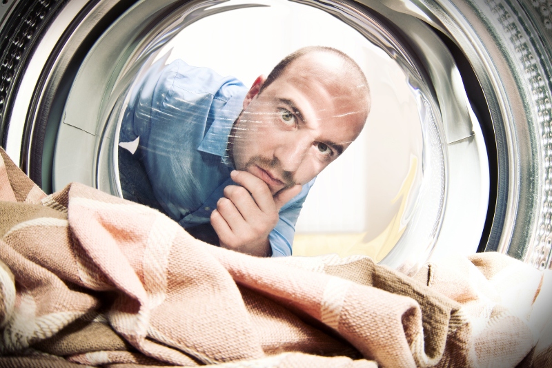 man looking inside washing machine