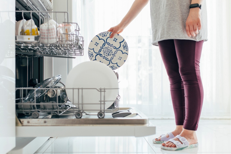 woman using dishwasher