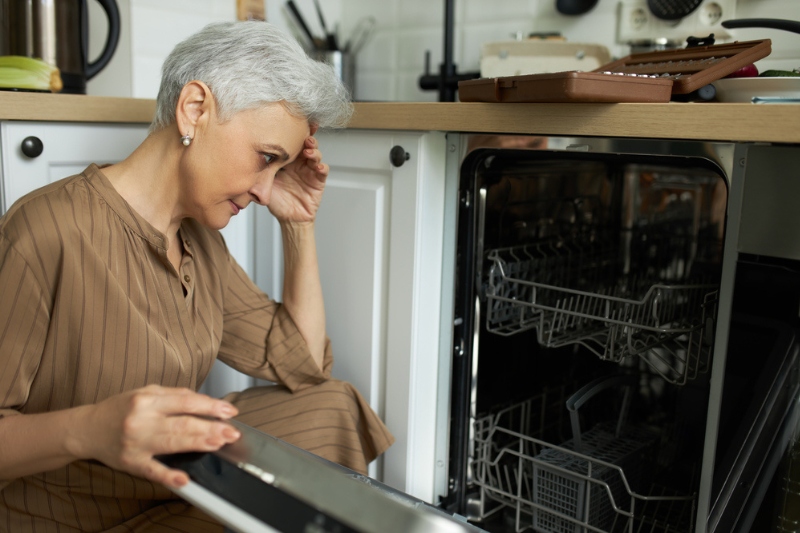 old woman with problematic dishwasher