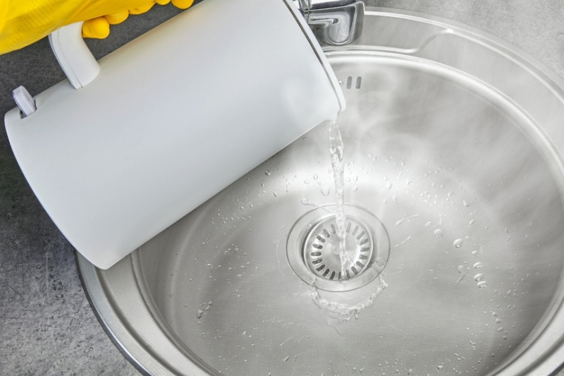 pouring boiling water in kitchen sink