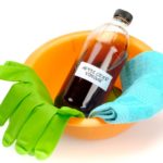 apple cider vinegar, cleaning gloves, cloth and small bowl