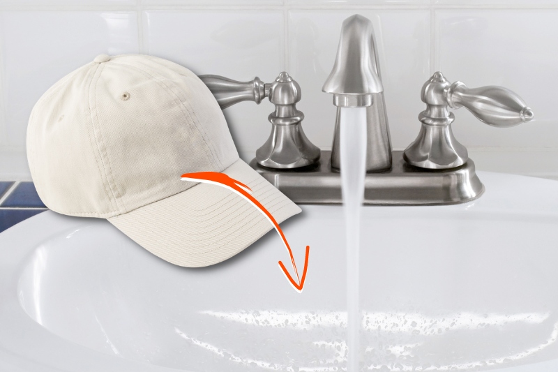 baseball cap in sink with water