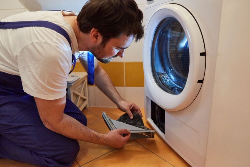 man repairing tumble dryer