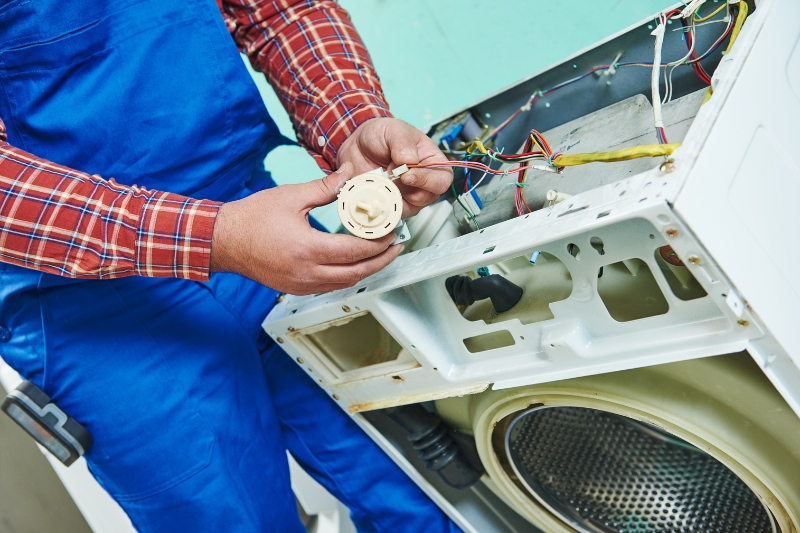 man repairing washing machine water level sensor