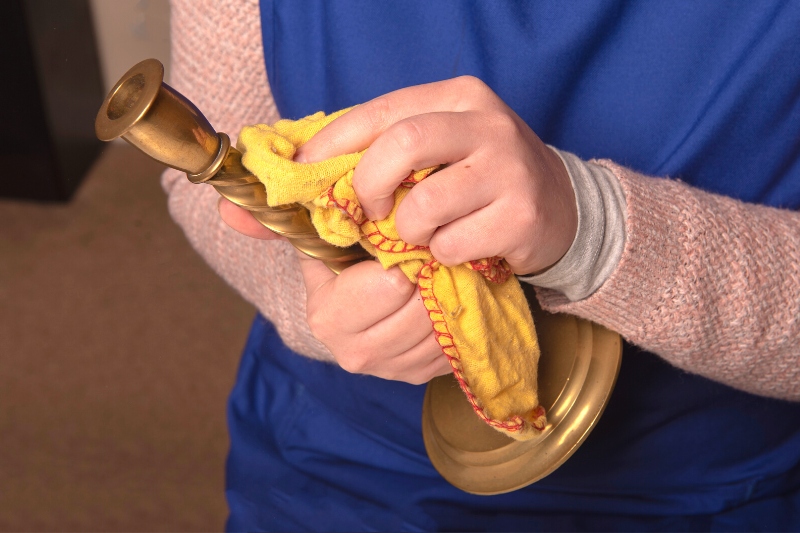woman cleaning brass