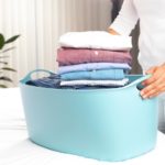 woman holding laundry basket with folded clothes