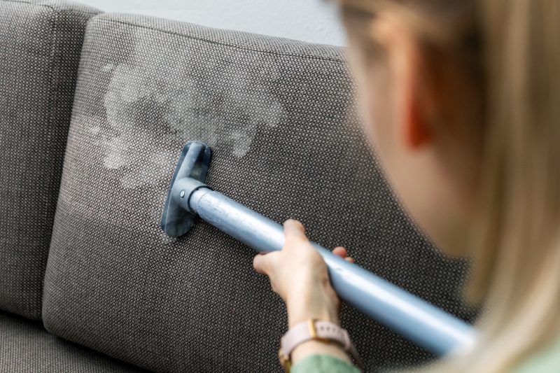 woman steam cleaning a sofa