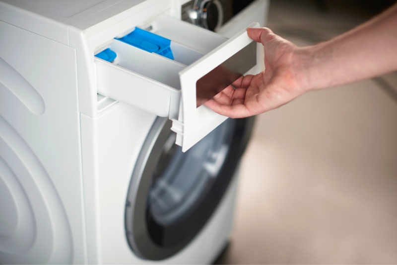 hand holding washing machine dispenser