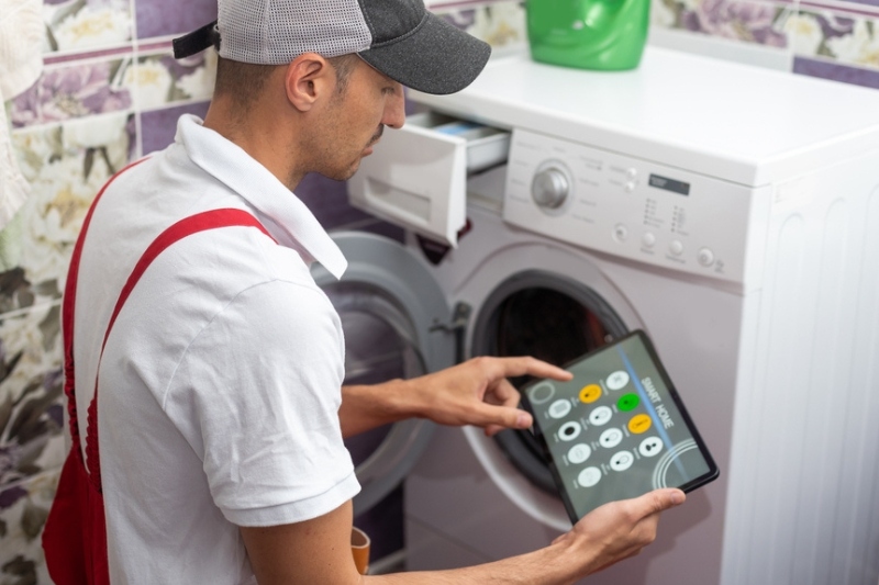 man controlling washing machine on smart app