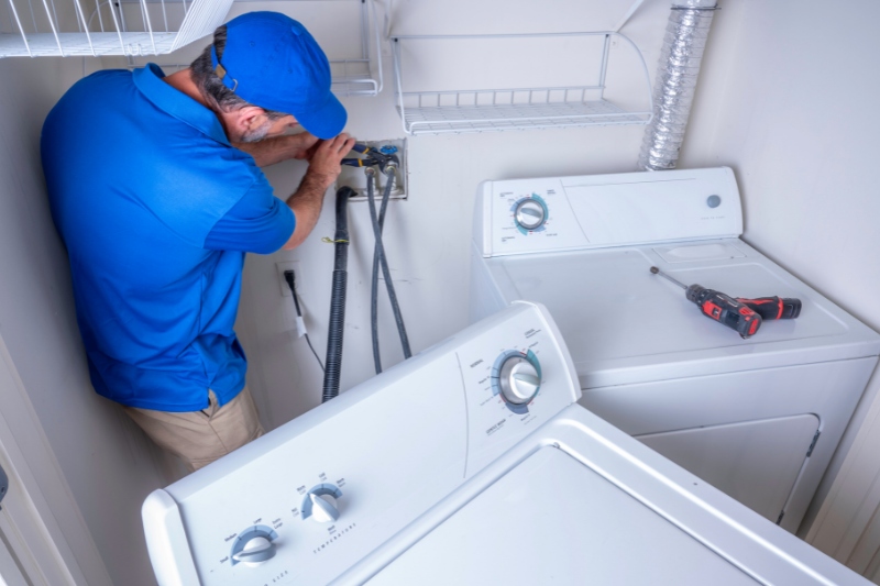 man installing washing machine water pipes