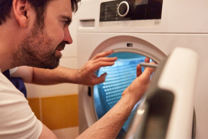 man repairing tumble dryer