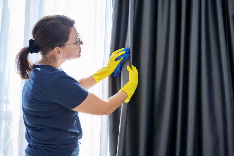 woman treating stains on curtains