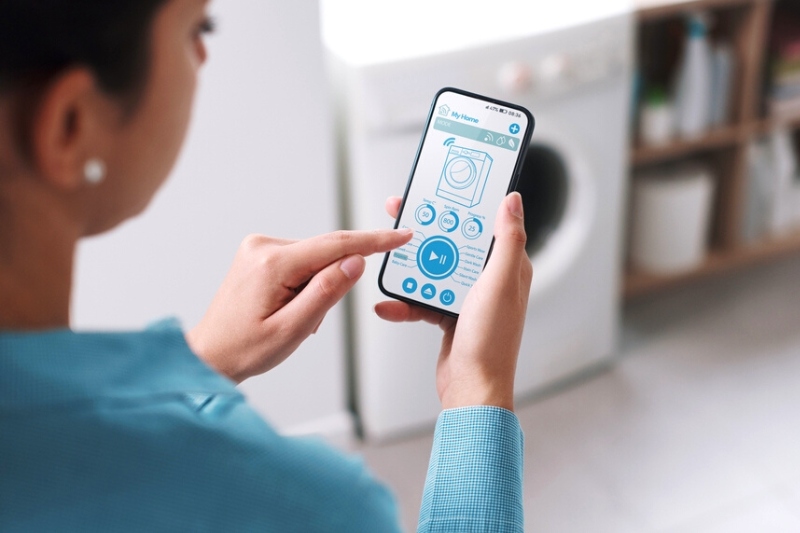 woman using phone to control washing machine