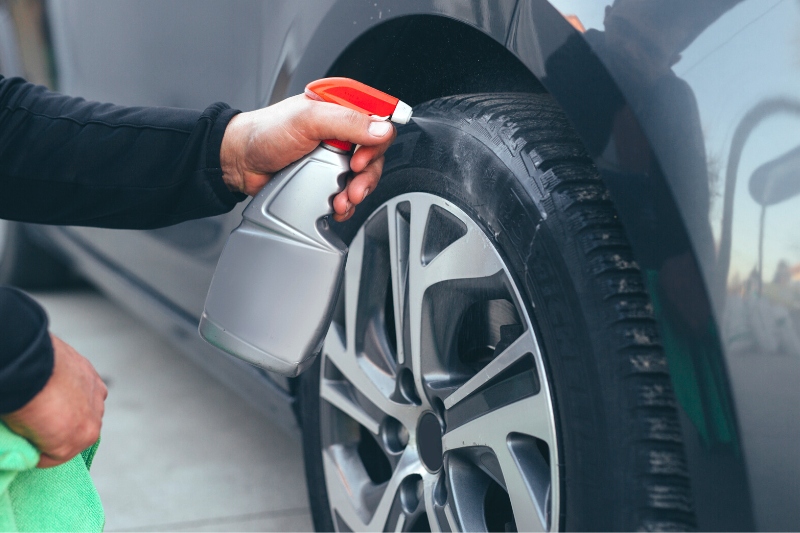 man cleaning car tyre