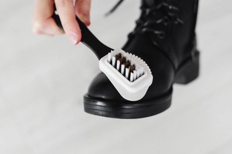 brushing black patent leather boot