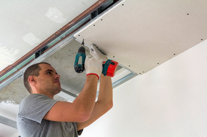 man doing repairs on ceiling