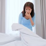 woman holding smelly blanket or bedding