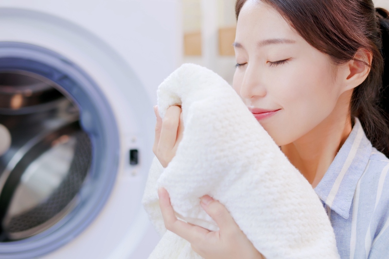 woman smelling freshly washed blanket