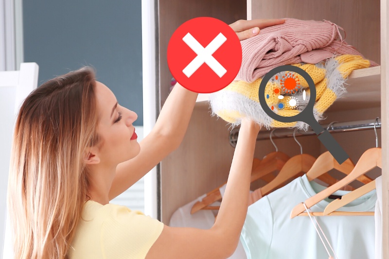 woman storing clothes in closet