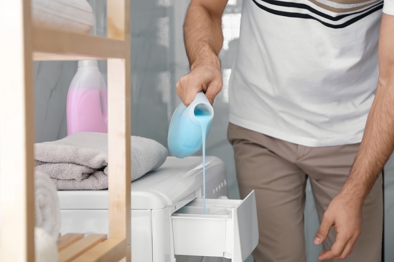 Pouring liquid detergent into drawer