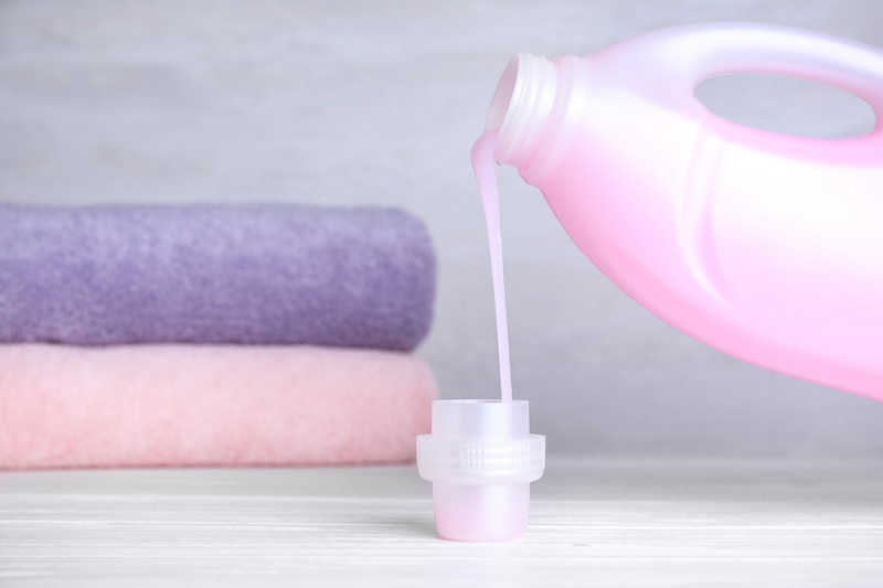 Pouring liquid detergent into lid