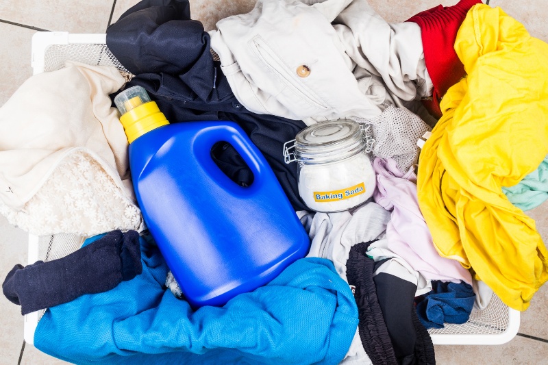 baking soda, liquid detergent and pile of laundry