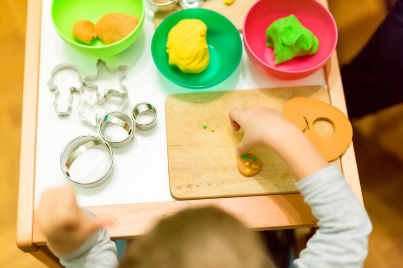 child playing playdough on table