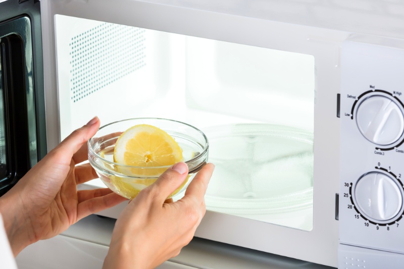 putting bowl with lemon in microwave