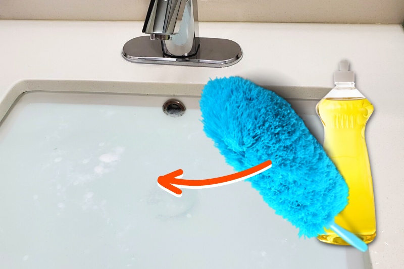 sink with water, washing up liquid and feather duster