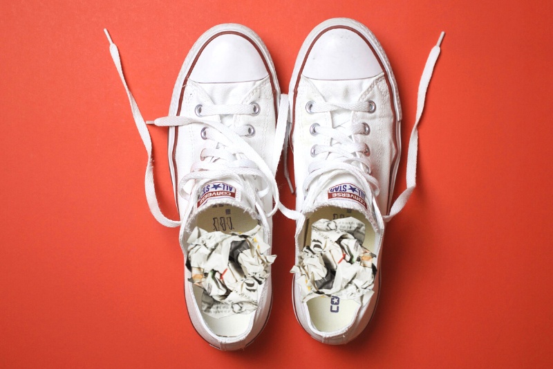 white converse with crumpled newspaper