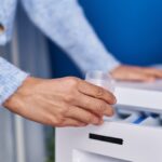 Putting laundry detergent in washing machine drawer