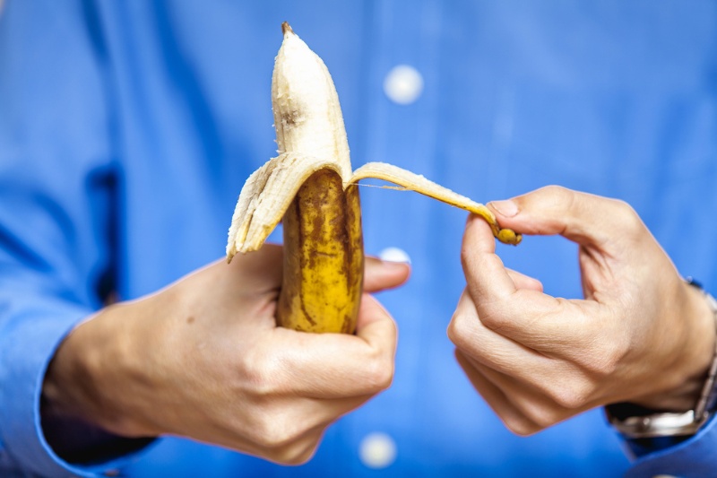 man peeling banana